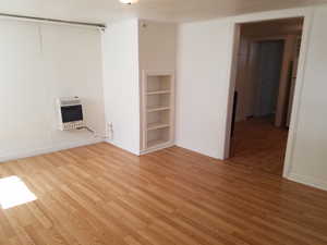 Spare room with light wood-type flooring and heating unit