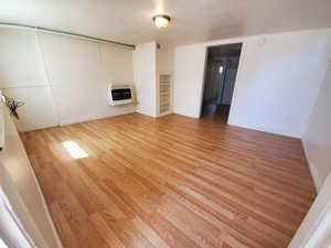 Unfurnished living room with light wood-style flooring and heating unit