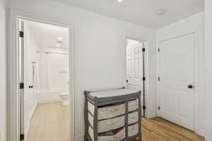 Bedroom featuring recessed lighting, light wood finished floors, and ensuite bathroom