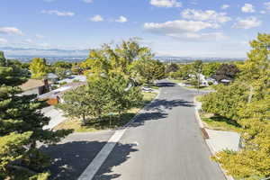 View of asphalt street with street lights, a residential view, and curbs