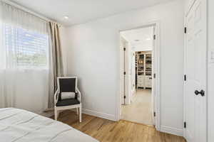 Bedroom with light wood-style flooring and a spacious closet