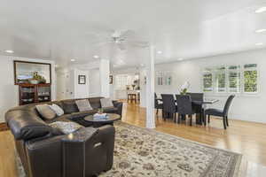 Living room featuring recessed lighting, light wood-style floors, and a ceiling fan