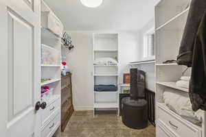 Walk in closet featuring dark carpet