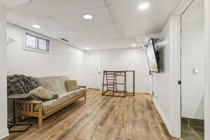 Living area with recessed lighting, light wood-style floors, and a paneled ceiling