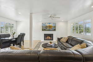 Living room featuring light wood-style floors, a fireplace with flush hearth, and recessed lighting