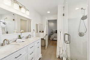 Ensuite bathroom featuring a stall shower, double vanity, and recessed lighting