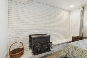 Tiled bedroom featuring brick wall and recessed lighting