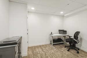 Office area with a drop ceiling, light carpet, and recessed lighting