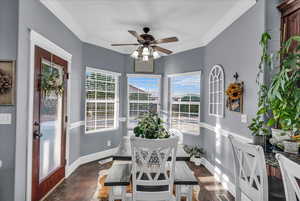 Sunroom featuring ornamental molding and baseboards