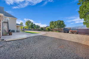 Fenced backyard with a patio, a balcony, and stairs