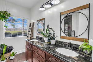 Bathroom with double vanity and concrete flooring