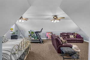 Bedroom with carpet floors and lofted ceiling