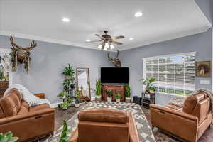 Living room featuring ornamental molding, a ceiling fan, and recessed lighting