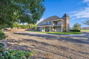 Rear view of house featuring a balcony and a shingled roof