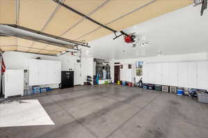 Garage with freestanding refrigerator and a garage door opener