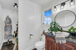 Half bathroom featuring vanity and toilet