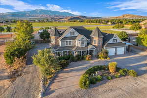 View of front of home with driveway, a mountain view, and stone siding
