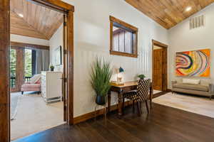 Hallway featuring vaulted ceiling, wood ceiling, hardwood / wood-style floors, and recessed lighting