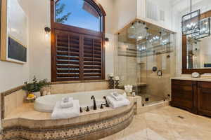Bathroom with a shower stall, a garden tub, vanity, and tile patterned flooring
