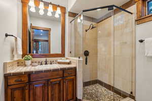Full bath with a shower stall, vanity, and decorative backsplash