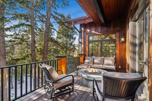 Deck featuring an outdoor living space with a fire pit