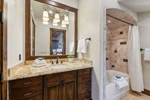 Full bath featuring shower / bath combo with shower curtain and vanity