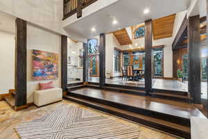 Foyer with high vaulted ceiling, stone tile flooring, and recessed lighting