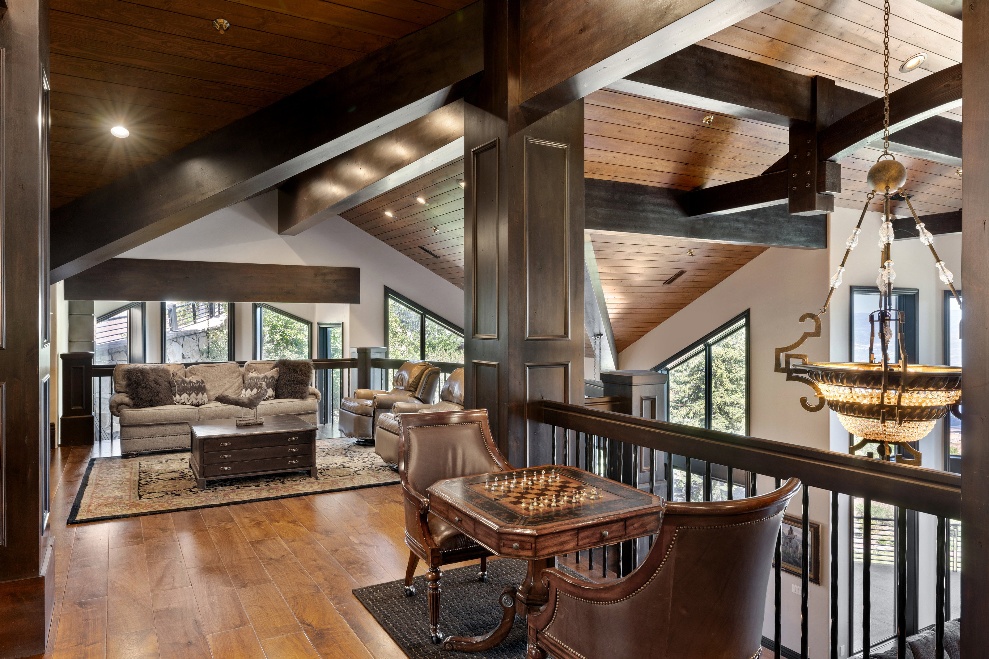 Living area featuring a chandelier, wood-type flooring, high vaulted ceiling, and a wooden ceiling with exposed beams