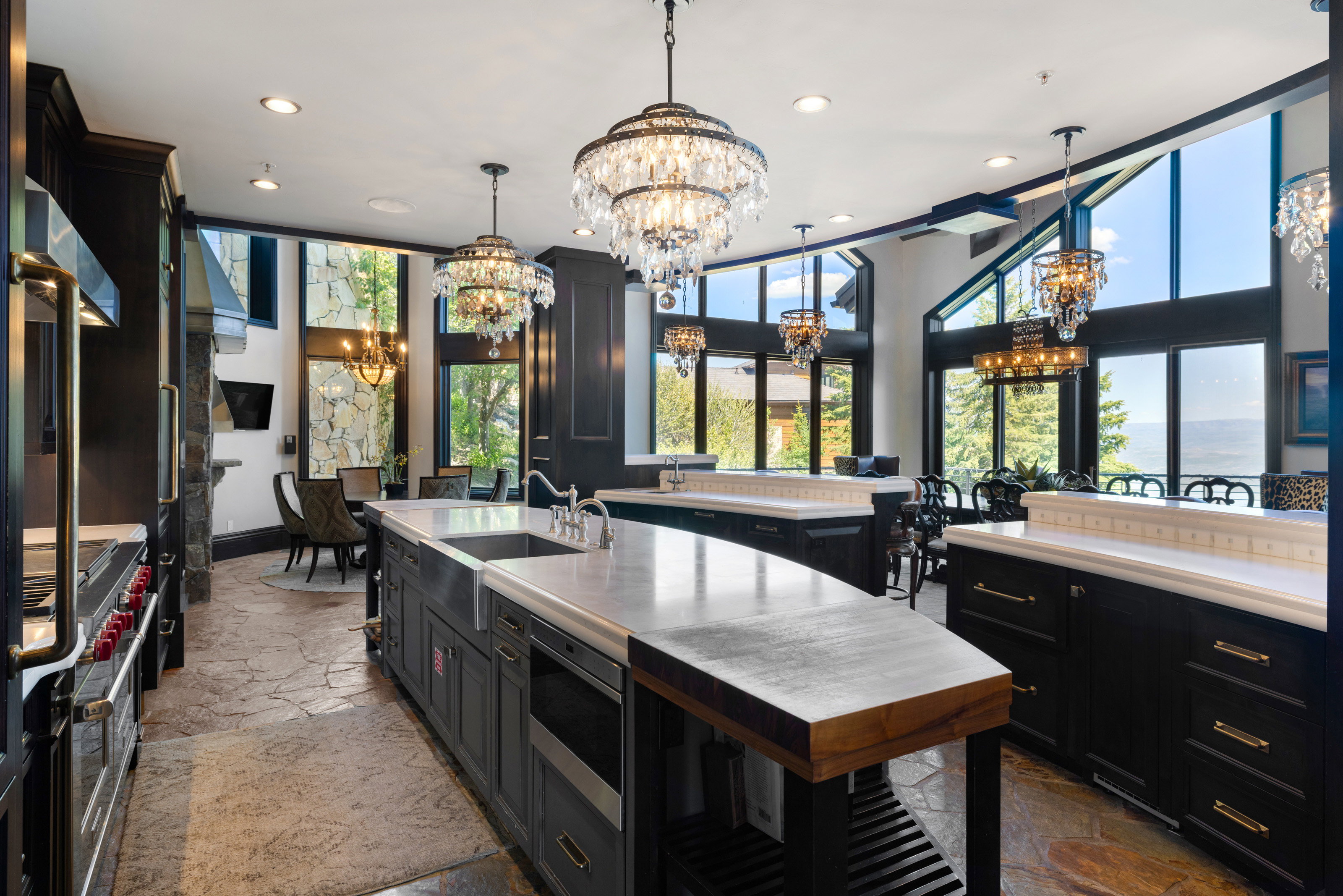 Kitchen featuring dark cabinets, stone tile floors, appliances with stainless steel finishes, healthy amount of natural light, and recessed lighting