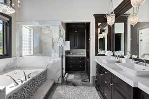 Bathroom with a chandelier, double vanity, a marble finish shower, a garden tub, and dark marble finish flooring