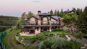 Back of property at dusk with a patio, a yard, a standing seam roof, a metal roof, and a gazebo