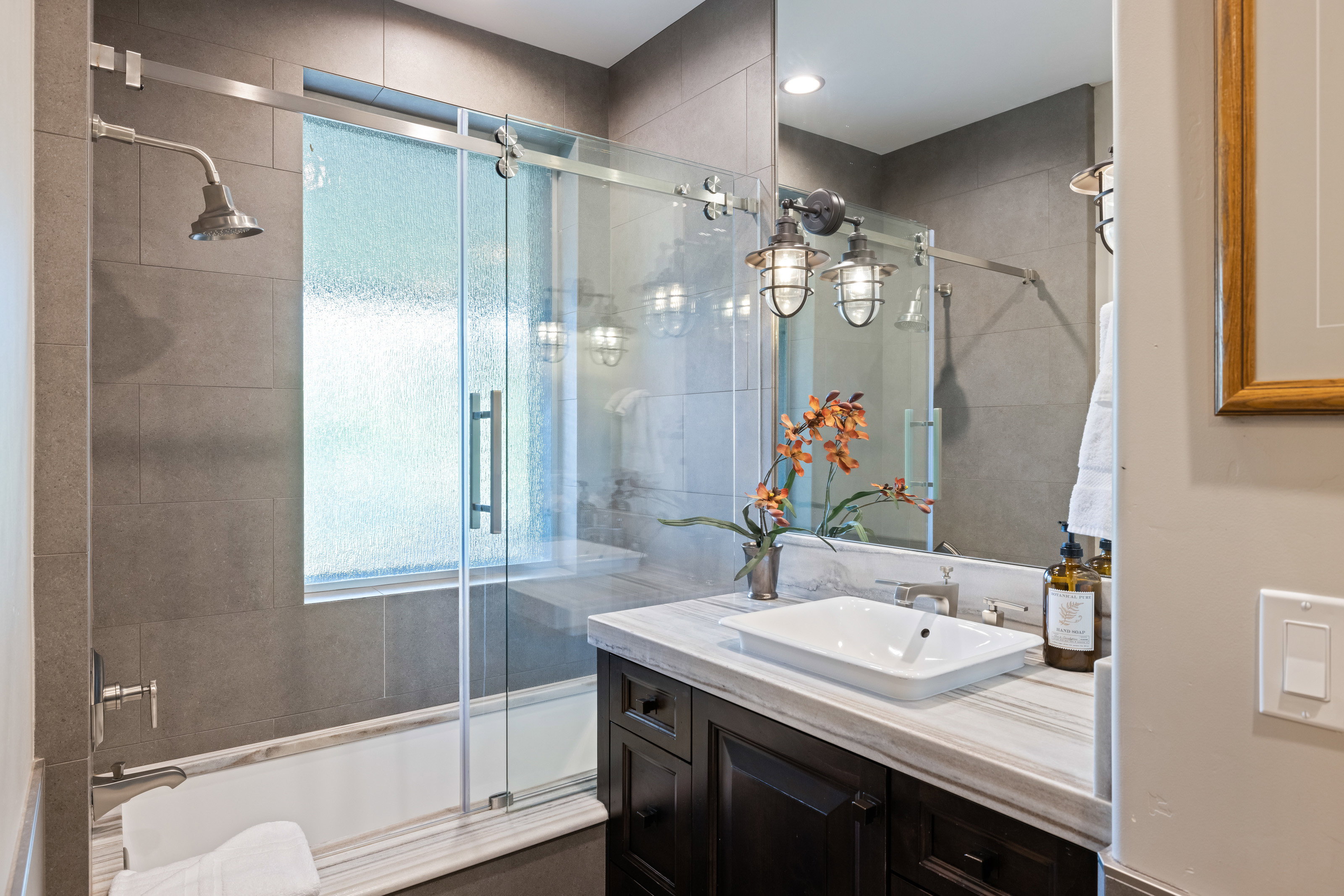 Bathroom featuring tiled shower / bath combo and vanity
