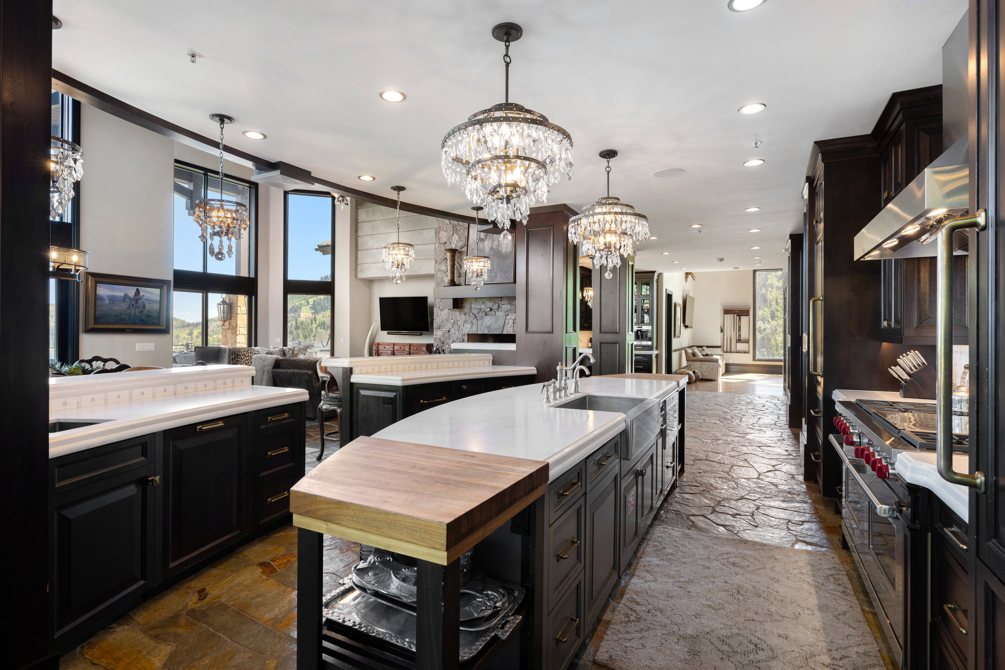 Kitchen featuring open floor plan, stone tile floors, a chandelier, decorative backsplash, and recessed lighting