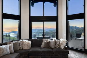 Living area featuring a towering ceiling, a mountain view, and healthy amount of natural light