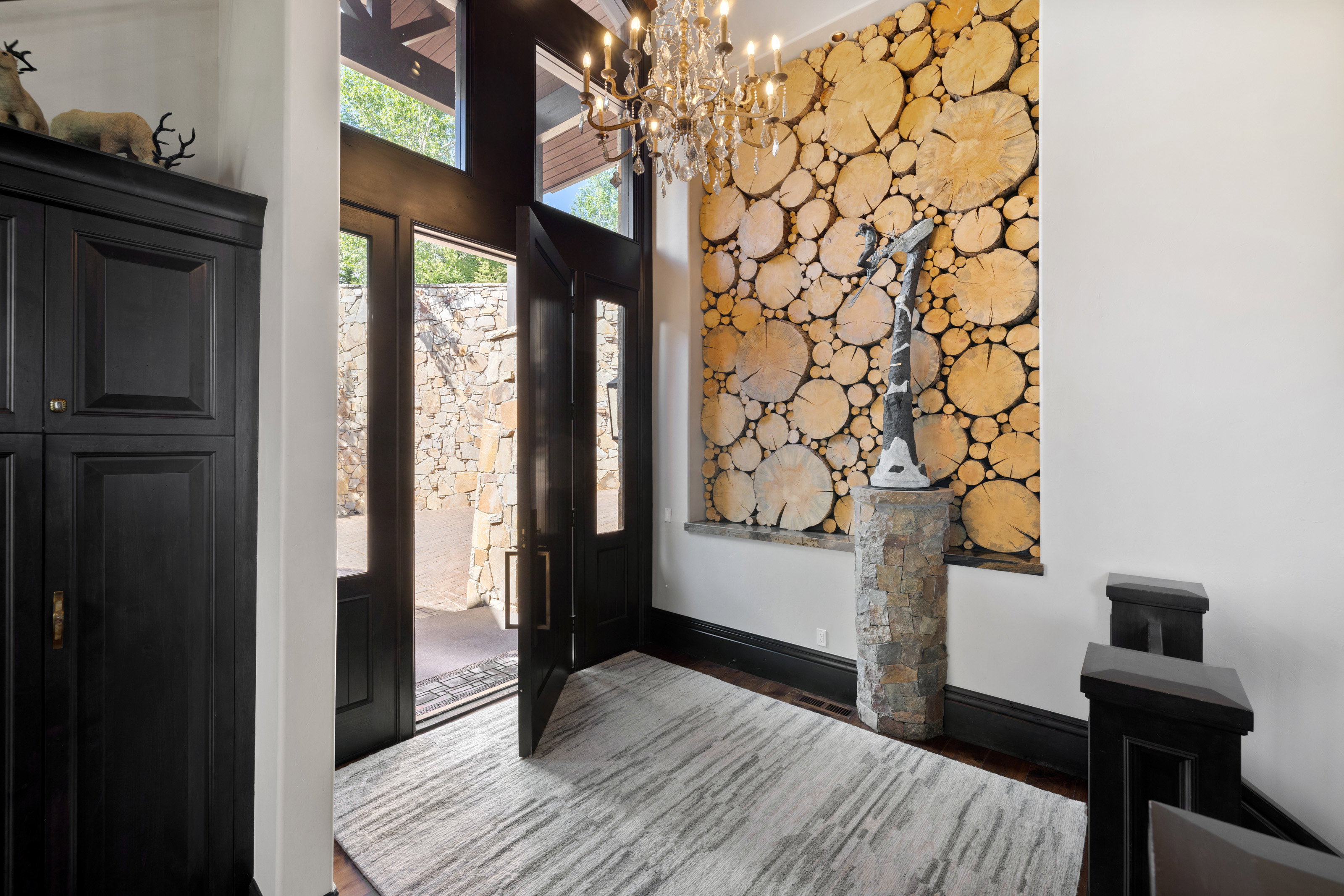 Foyer featuring wood finished floors, a chandelier, and a towering ceiling