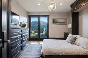 Bedroom featuring dark wood-type flooring, recessed lighting, access to outside, and a chandelier
