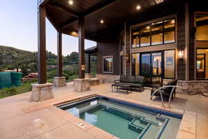 View of pool with a patio, a pool, and an in-ground hot tub