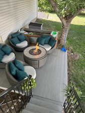 Wooden terrace with an outdoor living space with a fire pit and a yard