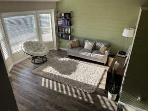 Living area featuring dark wood-style floors and wooden walls