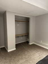 Unfurnished bedroom with carpet, a closet, and a textured ceiling