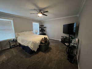 Bedroom with crown molding, dark carpet, and ceiling fan