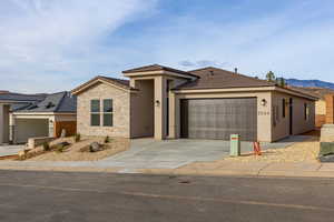 Prairie-style home with driveway, stucco siding, a garage, a mountain view, and a tiled roof