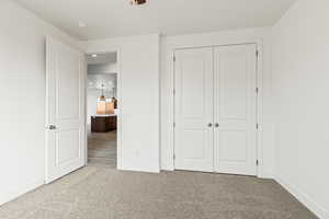 Unfurnished bedroom with light carpet and a closet