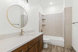 Bathroom with vanity, bathtub / shower combination, and wood tiled floors