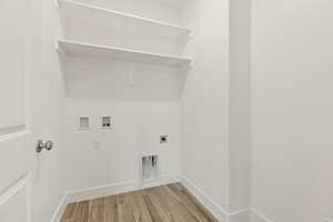 Laundry area with wood finish floors, washer hookup, and electric dryer hookup