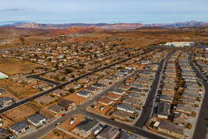 Aerial view of property and surrounding area with nearby suburban area and a mountainous background
