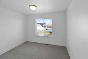 Carpeted spare room with baseboards