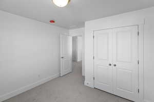 Unfurnished bedroom featuring carpet floors and a closet
