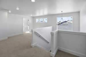 Hall featuring an upstairs landing, carpet flooring, healthy amount of natural light, and recessed lighting