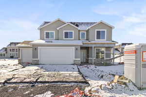 Traditional-style home with stucco siding, stone siding, and a garage